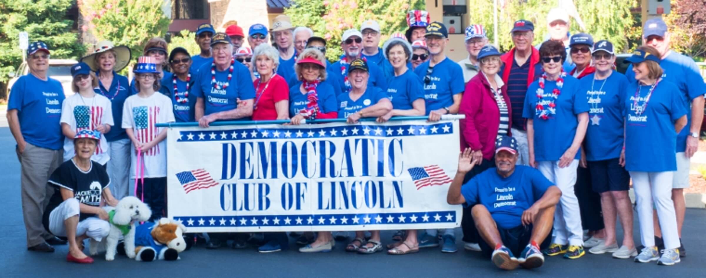 Group of smiling people dressed in patriotic colors holding a banner reading "democratic club of lincoln.